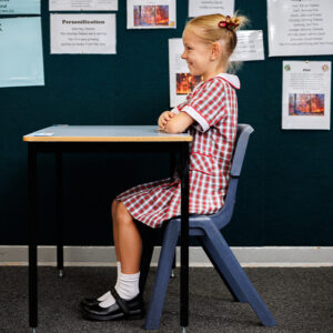 Schoolgirl demonstrating good posture at a schooldesk.